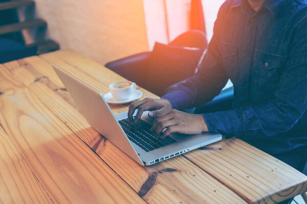 Рука бизнесмена, использующего ноутбук в кафе
