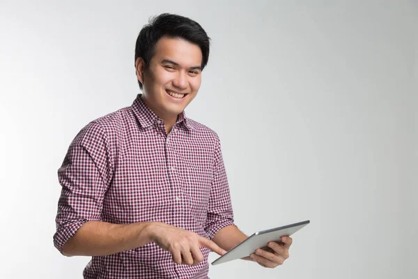 Joven asiático guapo hombre de negocios sonriendo celebración tableta y touc —  Fotos de Stock