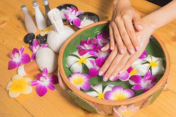 Vrouw handen met een kom van aroma spa water olieverf op houten tafel Rechtenvrije Stockfoto's