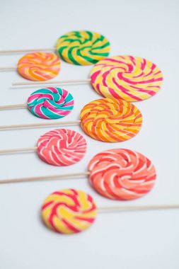 Şaşırtıcı lolipop beyaz masa üzerinde sopa üzerinde. Tatlı karamel şeker.