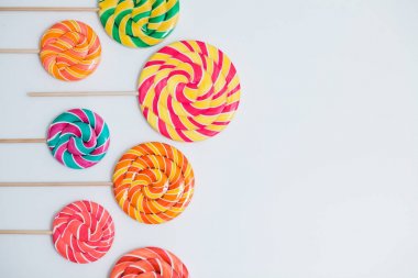 Şaşırtıcı lolipop beyaz masa üzerinde sopa üzerinde. Tatlı karamel şeker.