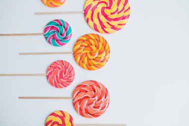 Şaşırtıcı lolipop beyaz masa üzerinde sopa üzerinde. Tatlı karamel şeker.