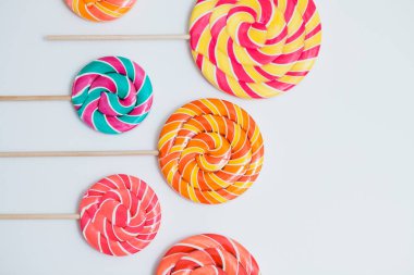 Şaşırtıcı lolipop beyaz masa üzerinde sopa üzerinde. Tatlı karamel şeker.