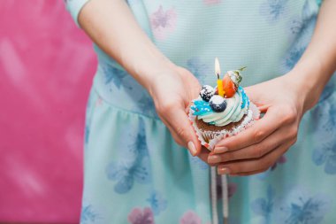 Kadın elinde tek mum ile doğum günü kek