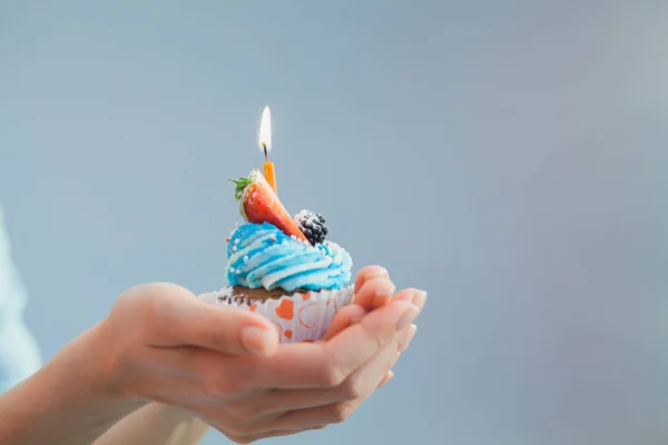 Doğum günü pastası eller mavi arka plan üzerinde tek mum. Holid — Stok fotoğraf