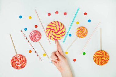 Çikolatalı şeker lolipop el beyaz arka plan yatıyordu düz desen