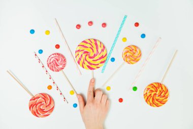 Çikolatalı şeker lolipop el beyaz arka plan yatıyordu düz desen