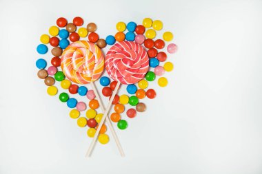 Çikolatalı şeker lolipop beyaz arka plan yatıyordu düz en az kalp