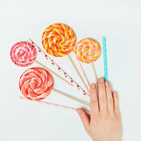 Lolipop plastik tüp el beyaz arka plan yatıyordu düz üst görünümü