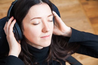 Genç kadın evde kulaklıklar, tüyler ürpertici. Müzikle sakin ol