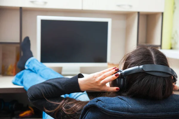 Молодая женщина в наушниках слушает музыку дома — стоковое фото