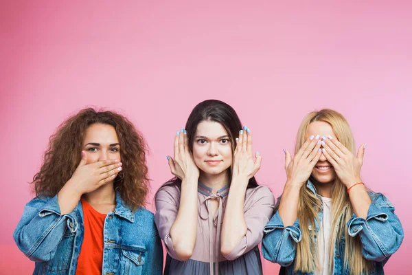 Three youg women as three wise monkeys. Mute, blind deaf