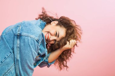 Denim giysileri kıvırcık saçlı güzel genç kadın