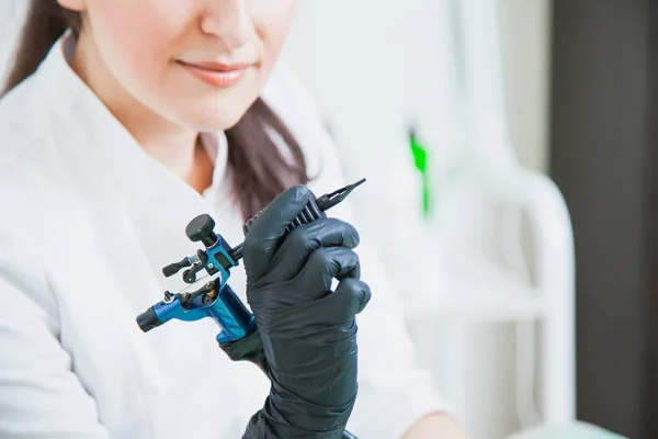 Cosmétologue féminine avec machine à tatouer — Photo