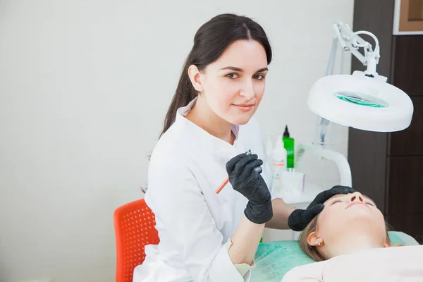 Kosmetolog tillämpa permanent makeup wit tatuering penna — Stockfoto