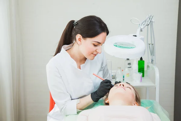 Kosmetolog tillämpa permanent makeup wit tatuering penna — Stockfoto