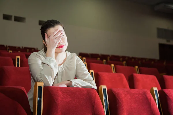 Žena zklamaná s představením v divadle nebo kině — Stock fotografie
