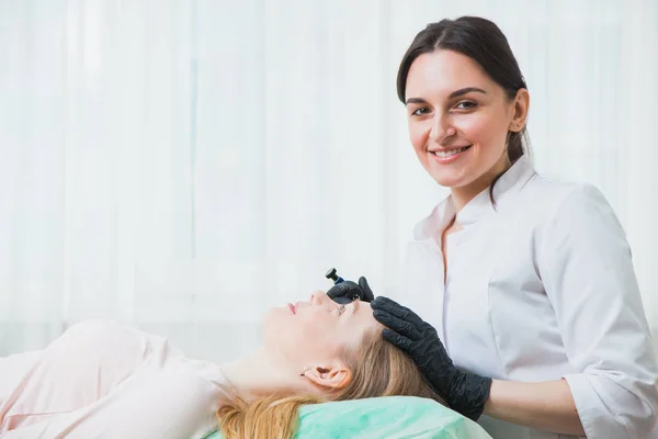 Beautician cosmetologist applying permanent makeup — Stock Photo, Image