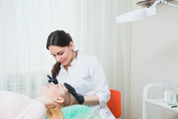 Esteticista cosmetologista aplicando maquiagem permanente — Fotografia de Stock