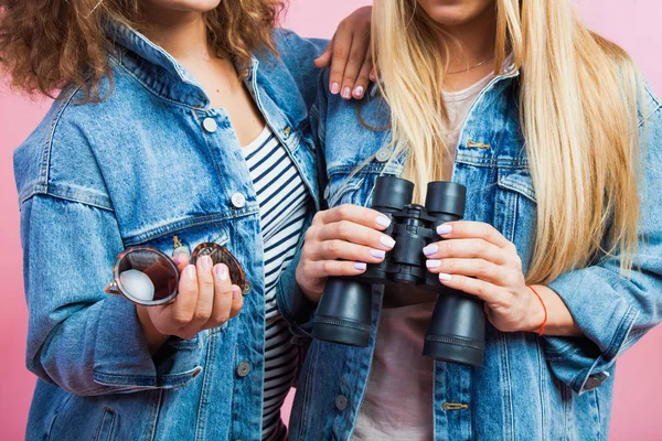 Two attractive women in jeans jackets with sunglasses and binoculars — Stock Photo, Image