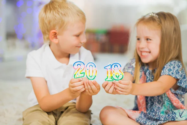 Bambini ragazzo e ragazza che tengono il nuovo anno 2018 — Foto Stock