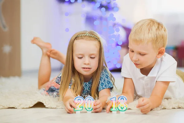 Hermanita y hermano juegan velas de año nuevo 2018 — Foto de Stock