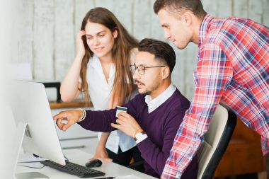 Bir grup bilgisayar monitörü yakınındaki ofiste iş insan