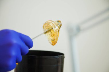 Sıvı şeker yapıştırma için saç çıkarma işlemini tutan kadın güzellik uzmanı el. Güzellik kavramı, epilasyon Güzellik Salonu.