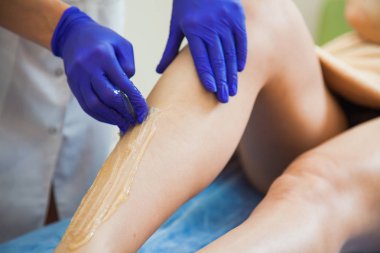 Genç kadın güzellik salonunda sugaring saç çıkarma işlemini yapma. Şevval Özçelik Güzellik Güzellik Uzmanı olun epilasyon sıvı şeker yapıştırın.