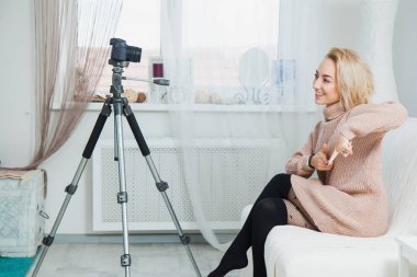 Bloglama kavramı. Video kamera evde yanındaki genç kadın bazen. Güzel kadın vlog ileti evde onu internet kanalı için kayıt