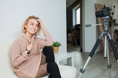 Bloglama kavramı. Video kamera evde yanındaki genç kadın bazen. Güzel kadın vlog ileti evde onu internet kanalı için kayıt