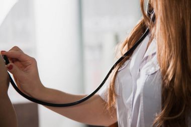 Kadın doctoc bir klinik tıp kabine, stetoskop ile muayene hasta. Sağlık ve hekim kavramı