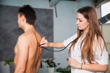 Kadın doctoc bir klinik tıp kabine, stetoskop ile muayene hasta. Sağlık ve hekim kavramı