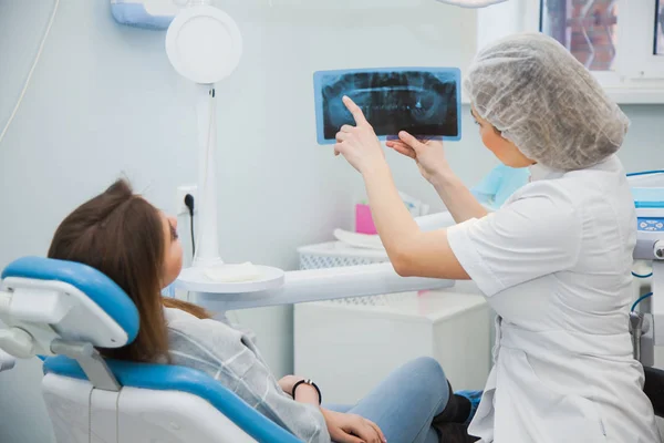 Stomatologist wyświetlone dental rentgenowskie obrazu do pacjenta w klinice office. — Zdjęcie stockowe