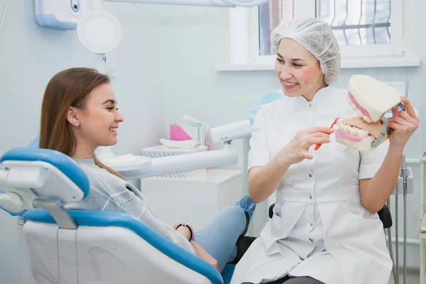 Kadın profesyonel diş hekimi diş hijyen çene model üzerinde göster — Stok fotoğraf
