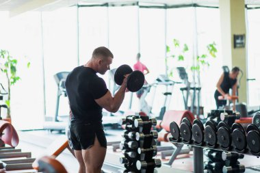 İyi donanımlı spor salonunda ağırlık kaldıran vücut geliştirici..