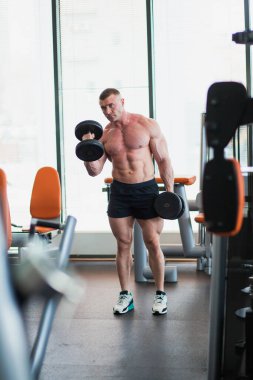 İyi donanımlı spor salonunda ağırlık kaldıran vücut geliştirici..