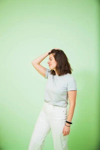 若いです幸せな女性でカジュアル服上の緑の背景. — ストック写真