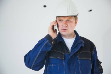 İnşaat alanında beyaz kasklı ustabaşı.