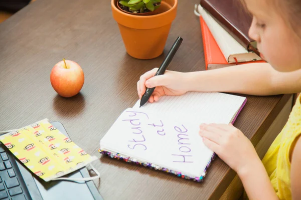 Closeup image of child medical antiviral mask write in notebook study at home.