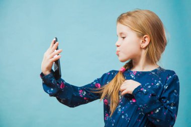 Küçük kız akıllı telefondan selfie çekiyor..