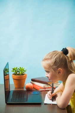 İnternet üzerinden evde eğitim gören mutlu ilkokul öğrencileri..
