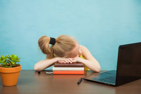 Mała uczennica szkoły podstawowej w masce przeciwwirusowej spać w pobliżu laptopa izolacji domu. — Zdjęcie stockowe