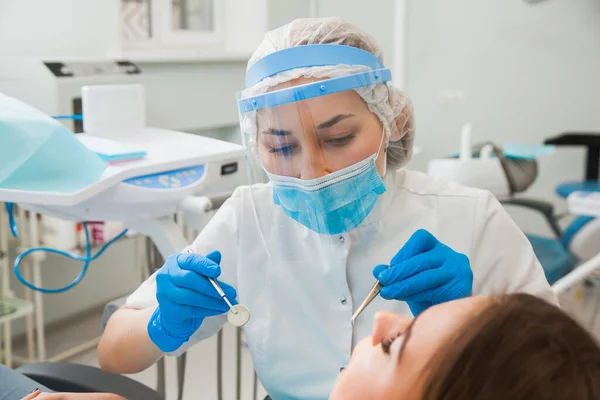 Młoda dentystka leczy pacjentów z ubytkiem zębów — Zdjęcie stockowe