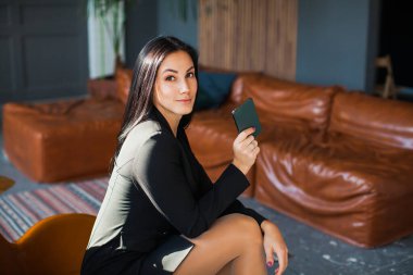 Evde akıllı telefon kullanan güzel seksi blogcu.