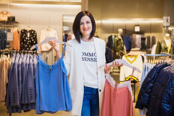 Young woman in clothes store choosing outfit.