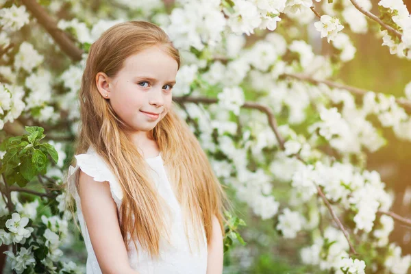Krásná dívka preteen s dlouhými blond vlasy těšit jarní jablko květ. — Stock fotografie