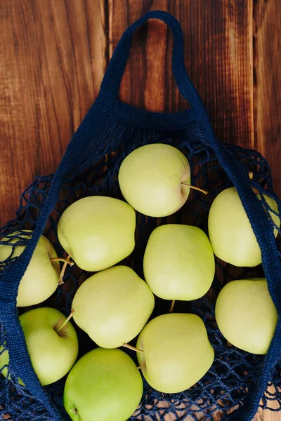 eco- friendly bag string bag with apple on a wooden background