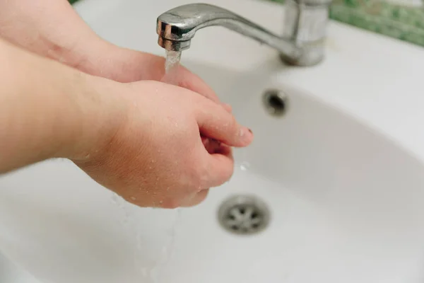 a man washes his hands with soap and water in the sink 1