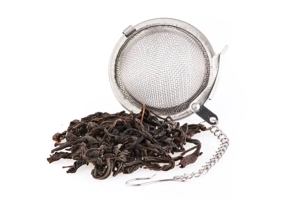 Черный чай, и ситечко с цепью, изолированные на белом фоне . — стоковое фото